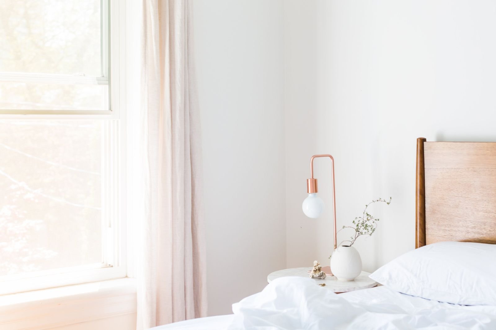 Gentle morning light across a calm, uncluttered bedside